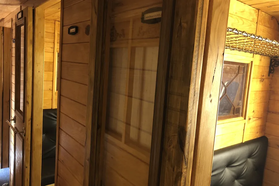 Boiseries d'un wagon fabriqué sur mesure : lambris, portes et banquettes